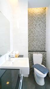 纳泰海滩APA-大树精品酒店的浴室配有白色卫生间和盥洗盆。