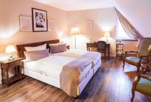 吕贝克吕贝克酒店古典城市线TOP酒店的一间卧室配有一张大床和两把椅子