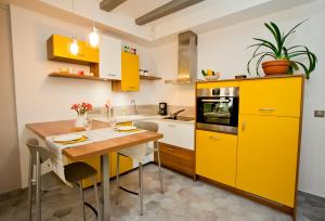 安锡Gite urbain AU 2BIS - Annecy的厨房配有黄色橱柜和木桌