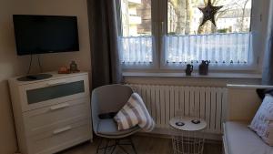 埃森Ferienwohnung Veit的客厅配有电视、椅子和窗户