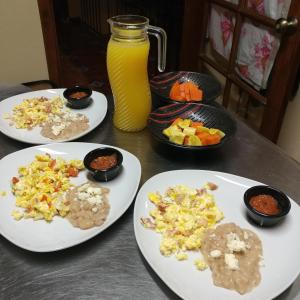 OcotlánHotel Posada Santa Fe的一张桌子,上面有三盘食物和一罐橙汁