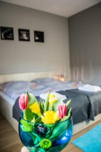 乌涅尤夫Pokoje Staromiejski的坐在桌子上的一碗鲜花和一张床