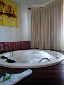 邦比尼亚斯Raio do Sol Residence的浴缸位于红色墙壁的房间