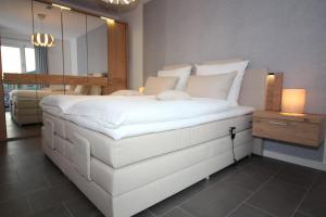 库克斯港Wohnen am Yachthafen W46的一张大白色的床,位于带镜子的房间里