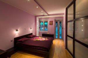 斯韦蒂·斯特凡Apartments Raymond的一间卧室配有一张紫色墙壁的床