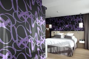 里尔贝斯维斯特高级酒店的一间卧室配有一张床和紫色的墙壁