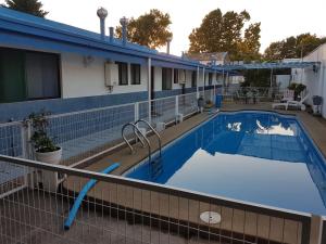 奇廉Hotel Los Cardenales的一座蓝色建筑的大型游泳池