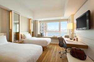 香港香港JEN酒店 香格里拉集团的酒店客房设有两张床、一张桌子和一台电视。
