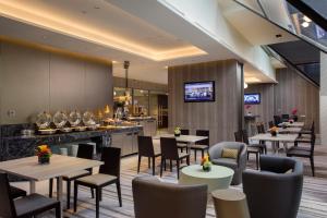 新加坡Carlton Hotel Singapore的一间带桌椅的餐厅和一间酒吧