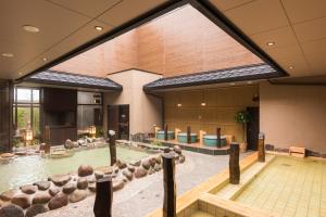 仙台仙台海滨通多米快捷酒店 的大型室内游泳池,位于带大窗户的建筑内