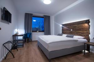 丁克拉格Hotel Wiesengrund Business & Boutique的配有一张床、一张书桌和一扇窗户的酒店客房