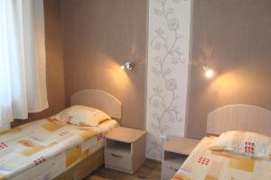 LyubimetsHotel Maritsa的一间卧室配有两张床和两张桌子