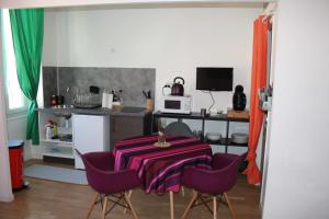 马赛卡萨阿米拉蒂公寓 的厨房配有桌子和一些紫色椅子