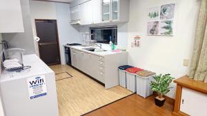 白滨白滨町海洋度假屋的小厨房配有白色橱柜和冰箱。