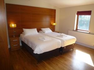 卡斯尔马特Castlemartyr Holiday Lodges 2 Bed的一间卧室配有一张大床和木制床头板