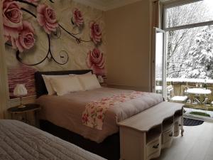 埃佩尔奈La Demeure d'Elodie的卧室配有一张墙上玫瑰床。