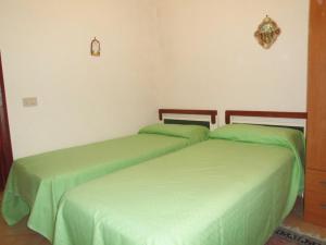 卡斯泰拉马莱Villa bellavista的配有绿床单的客房内的两张床