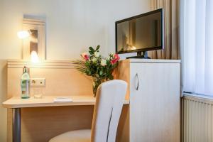 曼海姆莱茵内卡尔酒店的客房设有一张桌子、一台电视和一把椅子
