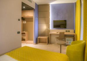 卡尔达诺阿尔坎波马尔彭萨卡达诺酒店的客厅配有书桌和黄色沙发