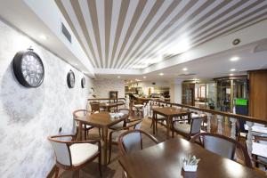 维戈Oca Ipanema Hotel的餐厅设有桌椅和墙上的时钟