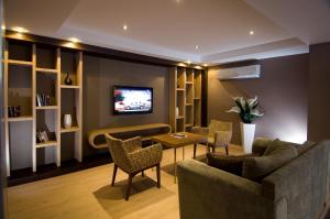 马尔马里斯苏普利姆酒店的客厅配有沙发、椅子和电视