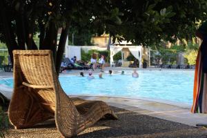 卡斯特拉巴特滨海妮可泰皮奈托酒店的游泳池旁的藤椅