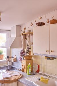 拜罗伊特Ferienwohnung Wilhelmine的厨房配有白色橱柜和水槽