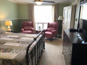 迪格比海边宾馆的一间卧室配有一张床、两把椅子和一个窗户