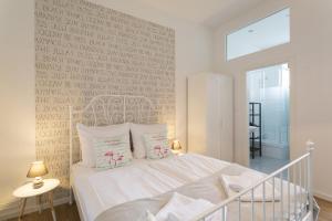 柏林Stylish & Cosy Apartment in Berlin, WiFi的卧室配有白色的床和写字墙