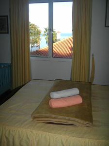 圣克鲁斯ANA旅馆的一张带两条毛巾的床铺,放在带窗户的木制托盘上
