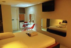 累西腓Rhodes Hotel Recife的一间带两张床和一张桌子的卧室以及一间厨房