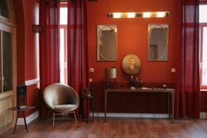 维姆勒Hotel Des Arts的一间设有红色墙壁、椅子和镜子的客房