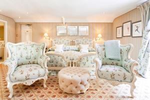厄维召特Summer Lodge Country House Hotel的客厅配有两把椅子和一张床