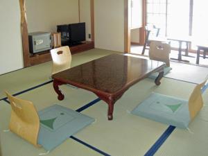 松本上高地西伊豆山日式旅馆的客厅配有咖啡桌和椅子