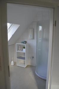 迪尔门Ferienwohnung Tiberquelle的带淋浴和冰箱的白色浴室