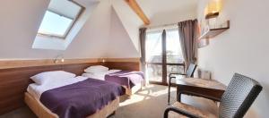 梅尔诺Willa Focus的一间卧室设有两张床、一张桌子和一个窗口。