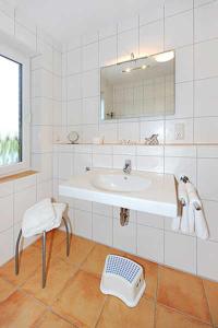 贝塞尔Nordseegartenpark Terrassien的浴室设有水槽、椅子和镜子