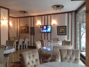 伊斯坦布尔图凡酒店的一间带桌椅的餐厅以及墙上的电视