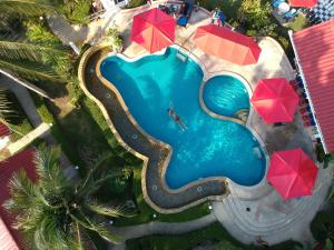 象岛顶级度假酒店的享有带红伞的游泳池的顶部景致