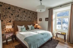 维森Boutique-Hotel Garni Bellevue Davos Wiesen的一间卧室配有一张床,墙上挂着 ⁇ 蝠