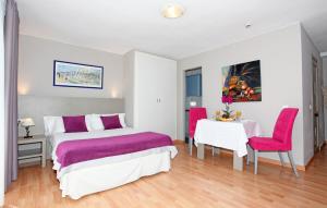 马贝拉埃尔法罗马贝拉酒店的卧室配有一张床和一张桌子及椅子