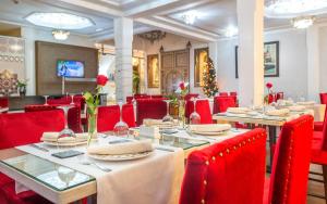 马拉喀什Hotel & Ryad Art Place Marrakech的用餐室配有桌子和红色椅子,并拥有圣诞树