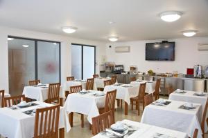 雷根古什-迪蒙萨拉什太阳阿尔克瓦酒店的一间带白色桌椅的餐厅和一间厨房