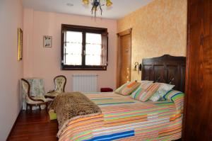 Gres卡皮亚旅馆的一间卧室配有一张带彩色毯子的床