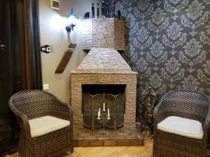 第比利斯Apartment Old Tbilisi Gorgasali的客厅设有石制壁炉及两把椅子