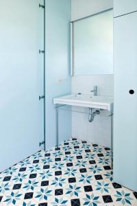 Entrena博德加芬卡洛斯阿迪诺斯酒店的浴室设有水槽,铺有黑白瓷砖地板。