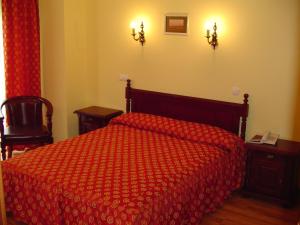 普洛耶什蒂欧洲酒店的一间卧室配有一张红色棉被的床