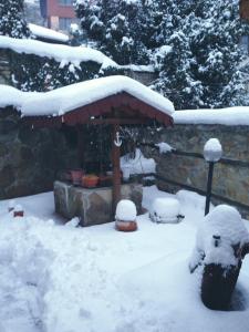 LovechHotel Bilyana的雪地覆盖的院子,凉亭