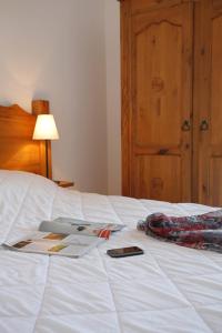 布齐耶比利牛斯2000普拉德拉酒店的一张带书的床铺和手机