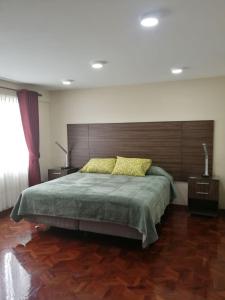 拉巴斯Miraflores Apart的一间卧室配有一张大床和木制床头板